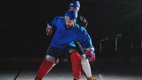 Zwei-Männer-Spielen-Hockey-Auf-Der-Eisbahn.-Hockey-Zwei-Hockeyspieler-Kämpfen-Um-Den-Puck.-Steadicam-Aufnahme